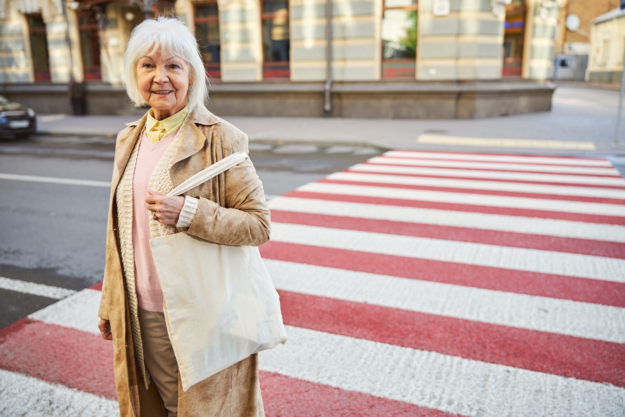 Outdoor portrait of senior female on the pedestrian crossing